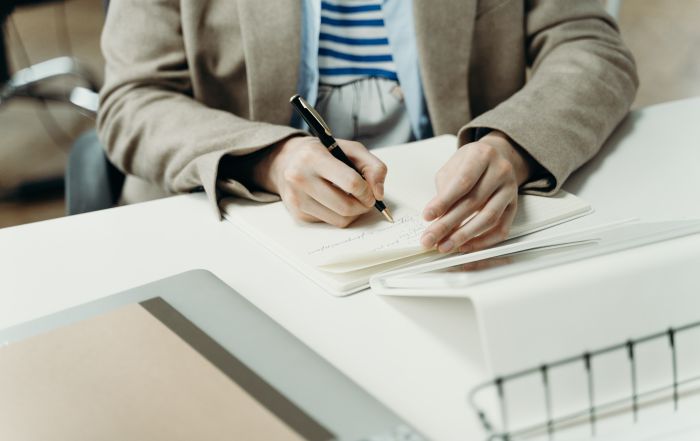 Close up van schrijvende medewerker reserveringen en sales werkzaamheden